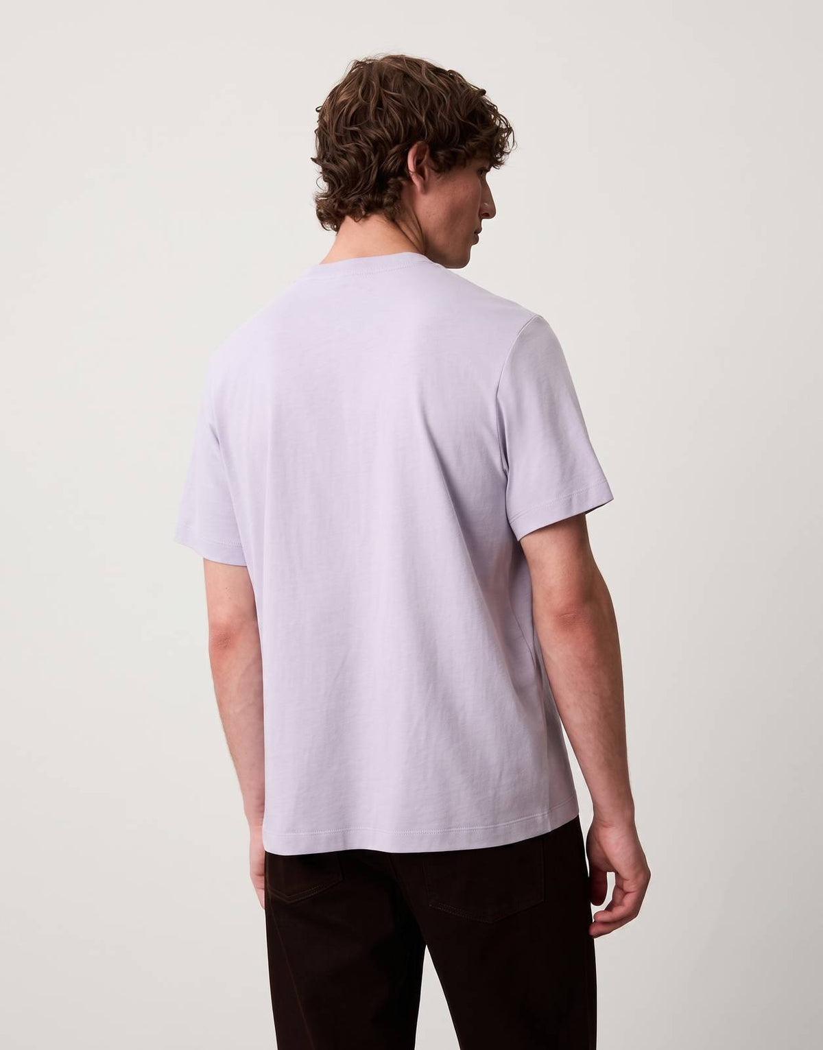 Calvin Klein 20s Calvin Script Graphic Light Blue T-Shirt, back view, worn by a male model. The t-shirt is made of soft