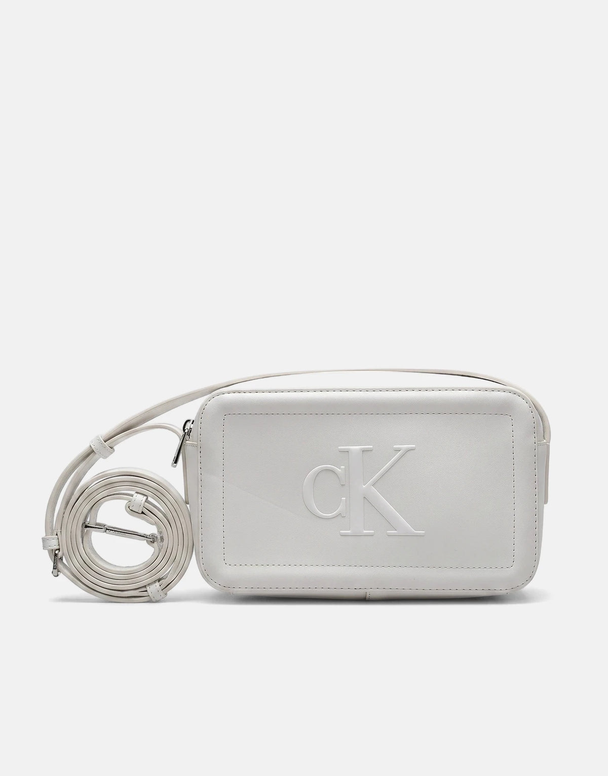 A white Calvin Klein Bold CK camera bag with an embossed logo and an adjustable strap, displayed from the front.