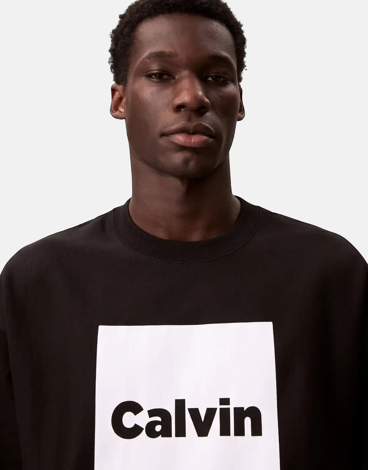 Calvin Klein Box Graphic Sweatshirt in black, worn by a male model, showcasing the white box logo.