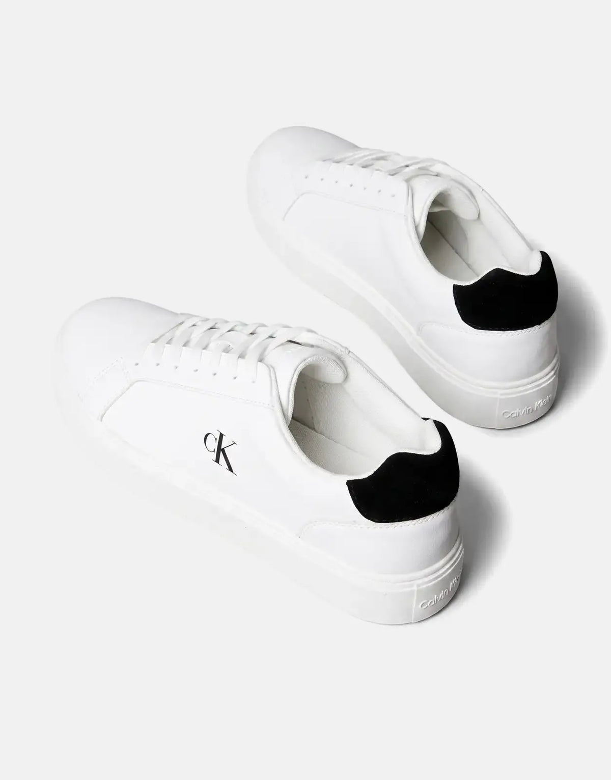 Two white Calvin Klein Classic Cupsole Sneakers with black CK logos and heel accents, displayed angled on a plain surface.