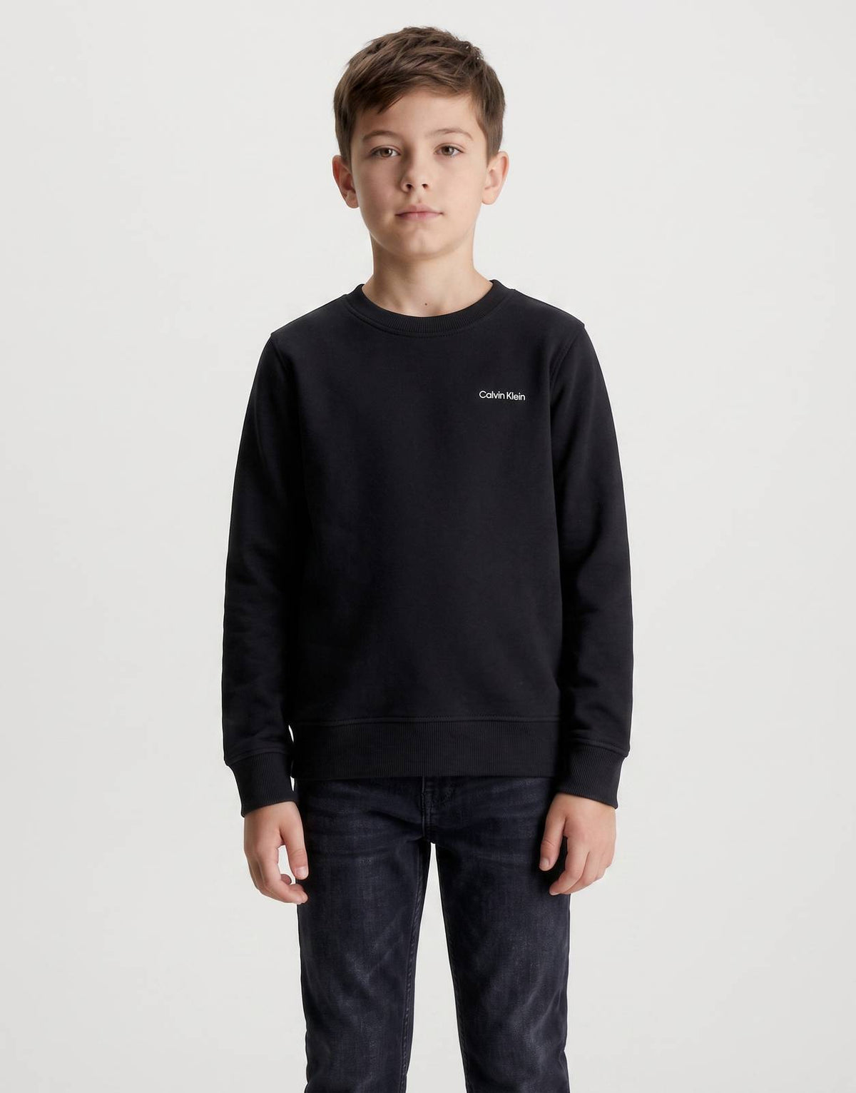 Young boy models a black Calvin Klein Kids Chest Instant Logo regular fit t-shirt, front view, highlighting the chest logo.