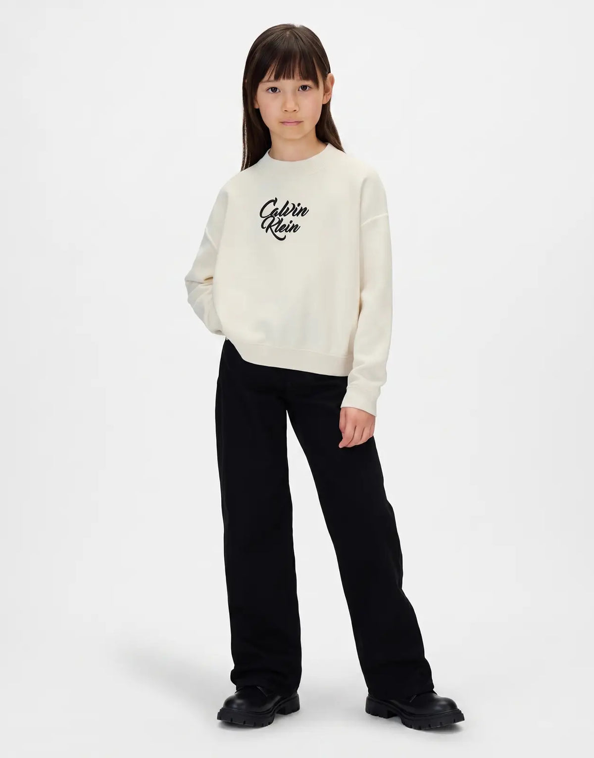 Calvin Klein Kids Script Logo Sweatshirt in cream, front view. A child models the long-sleeved crew neck top.