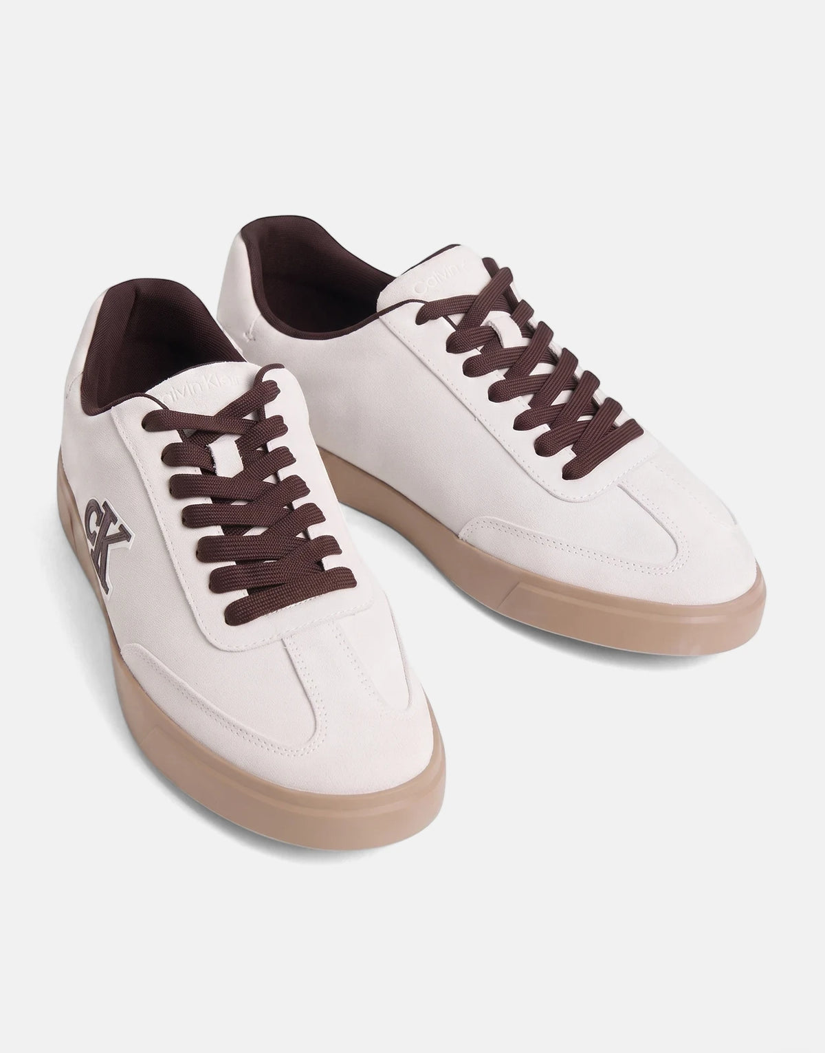A pair of Calvin Klein Low Prof White Multi Cupsole Sneakers with brown laces, shown from an angled perspective on a clean