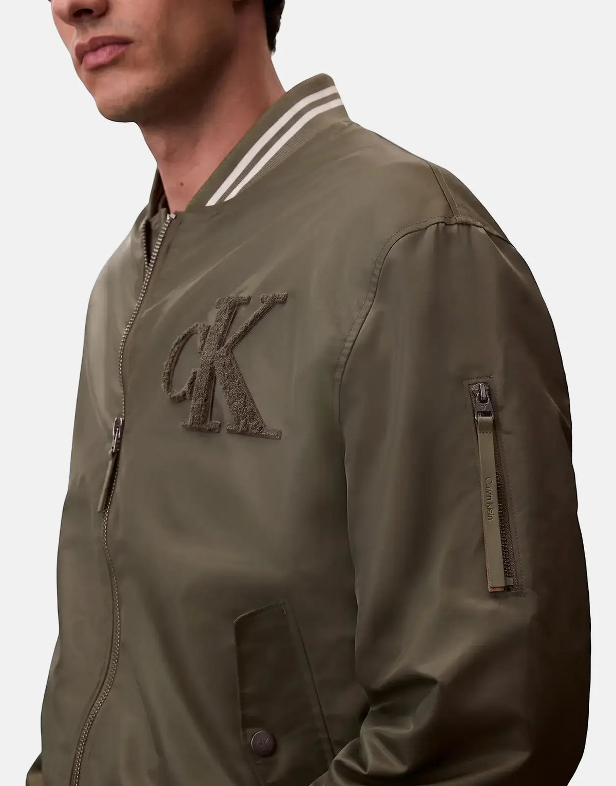 Calvin Klein Tipped Hero Bomber Jacket in olive green, featuring a prominent CK logo on the chest and striped collar.