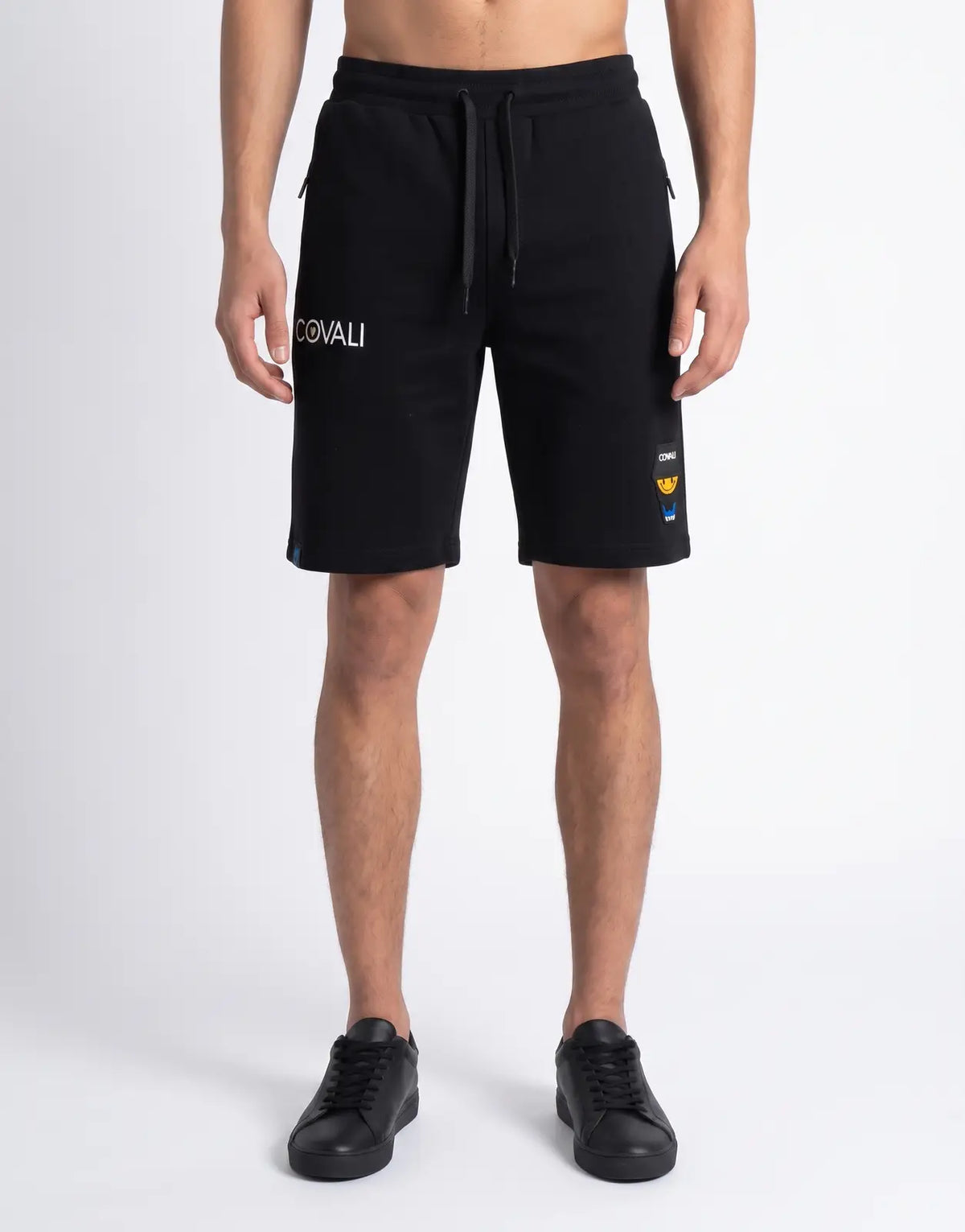 Men's Covali Tipo V black shorts with a drawstring waist and white logo detailing on the left leg, styled casually.