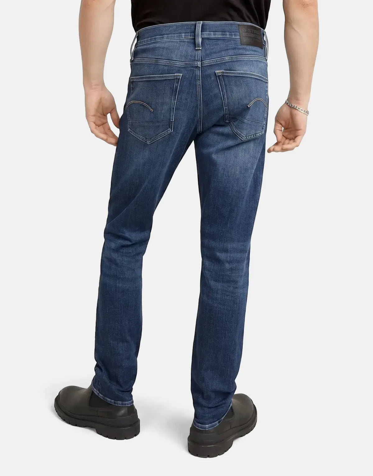 Men's G-Star RAW 3301 Slim Medium Aged Jeans in dark blue denim, shown from the back with black shoes.