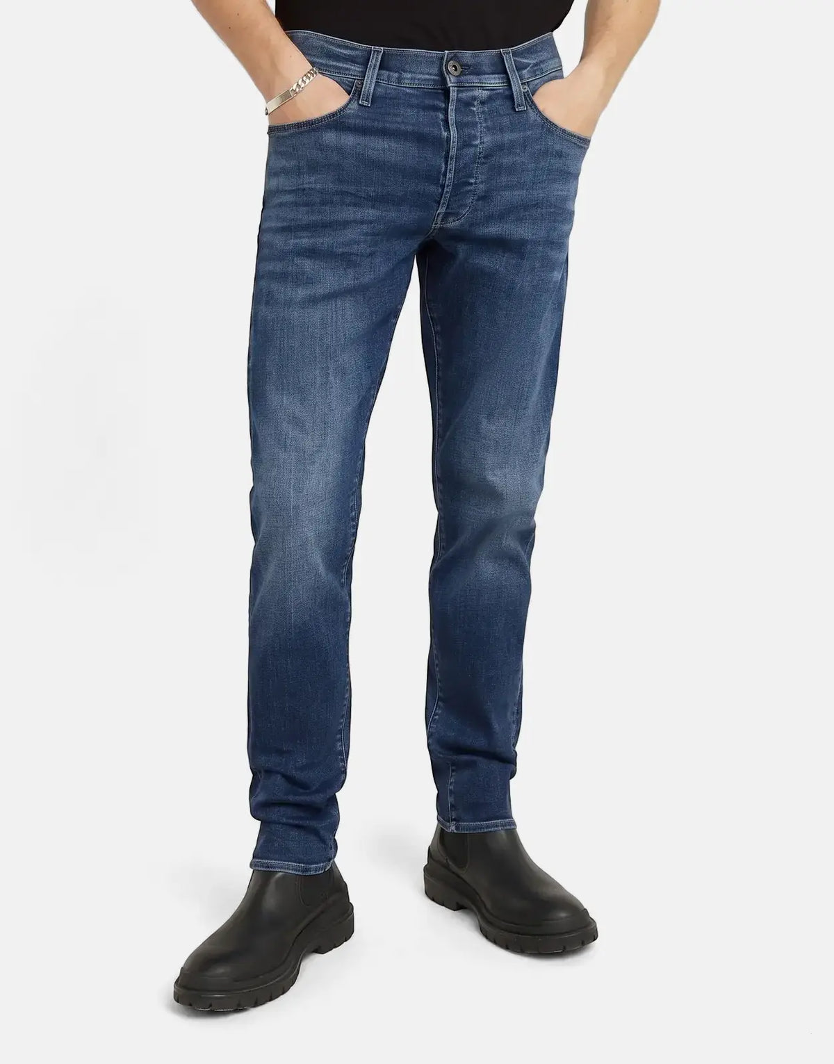 Male model showcasing G-Star RAW 3301 Slim Medium Aged Jeans in blue denim, featuring a slim fit and classic styling.