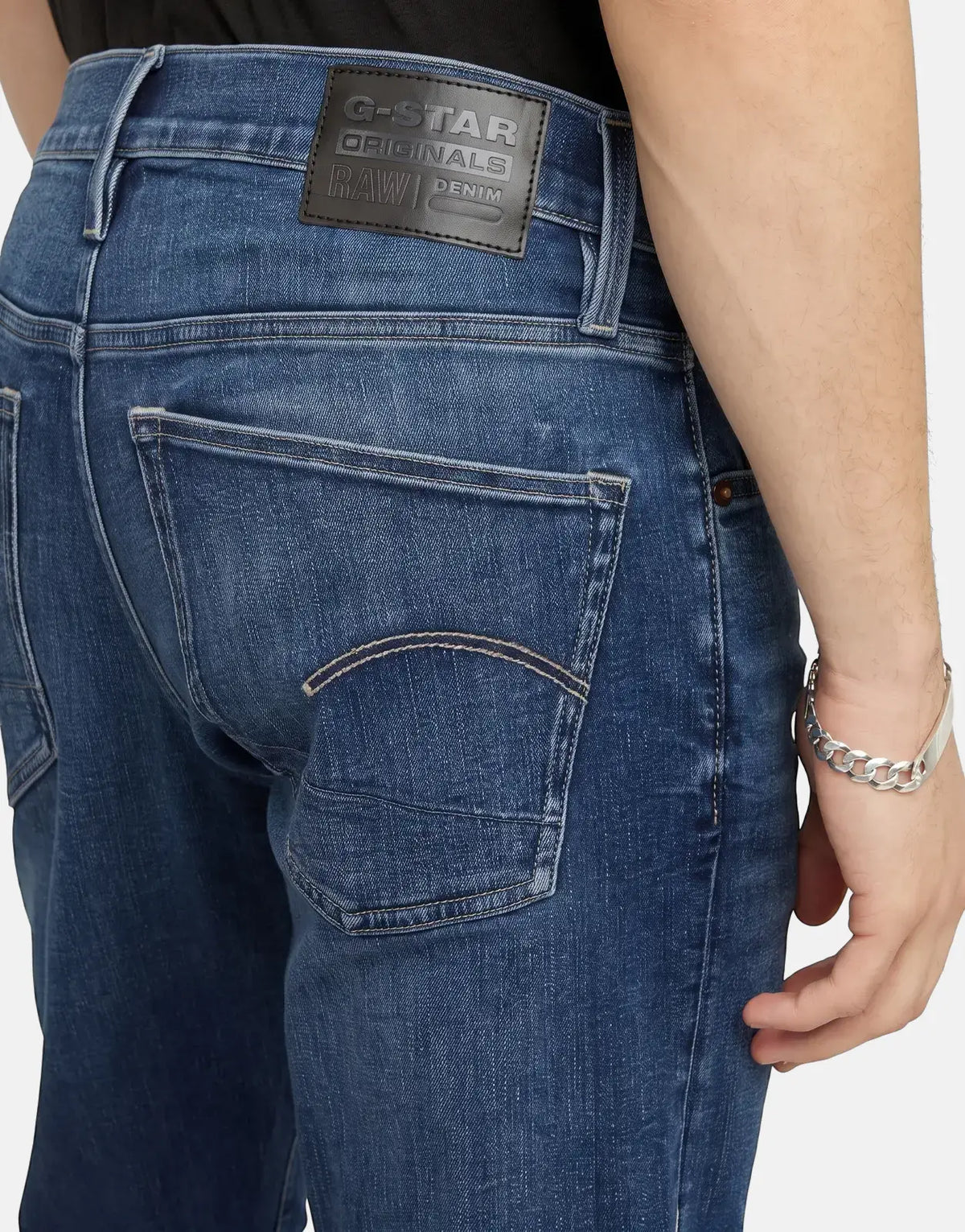 G-Star RAW 3301 Slim Medium Aged Jeans, rear view, showing brand patch, back pockets, and silver bracelet.