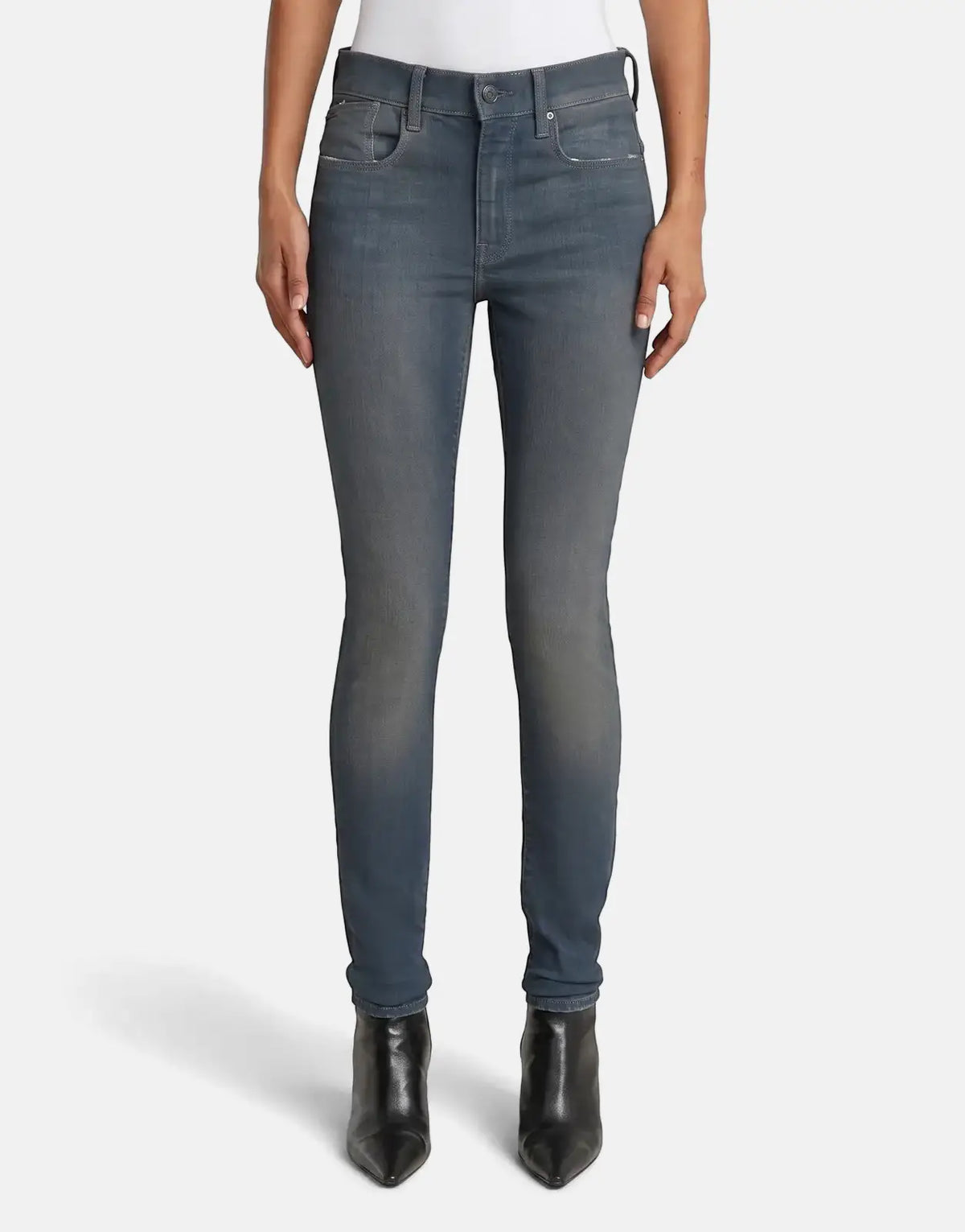 A person wears G-Star RAW Lhana skinny jeans in a worn smokey night blue. The jeans have a slim fit and visible stitching