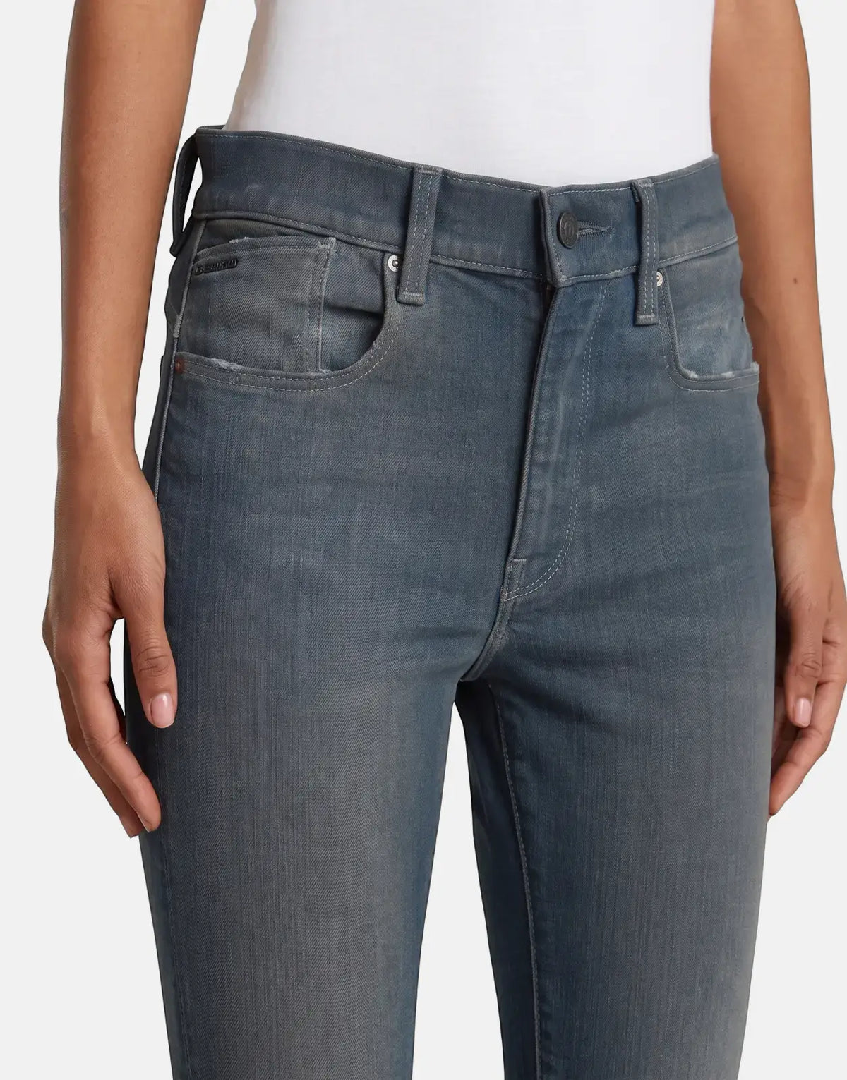 Close-up of a person wearing G-Star RAW Lhana Skinny Worn in Smokey Night Jeans, featuring a blue-grey wash and classic