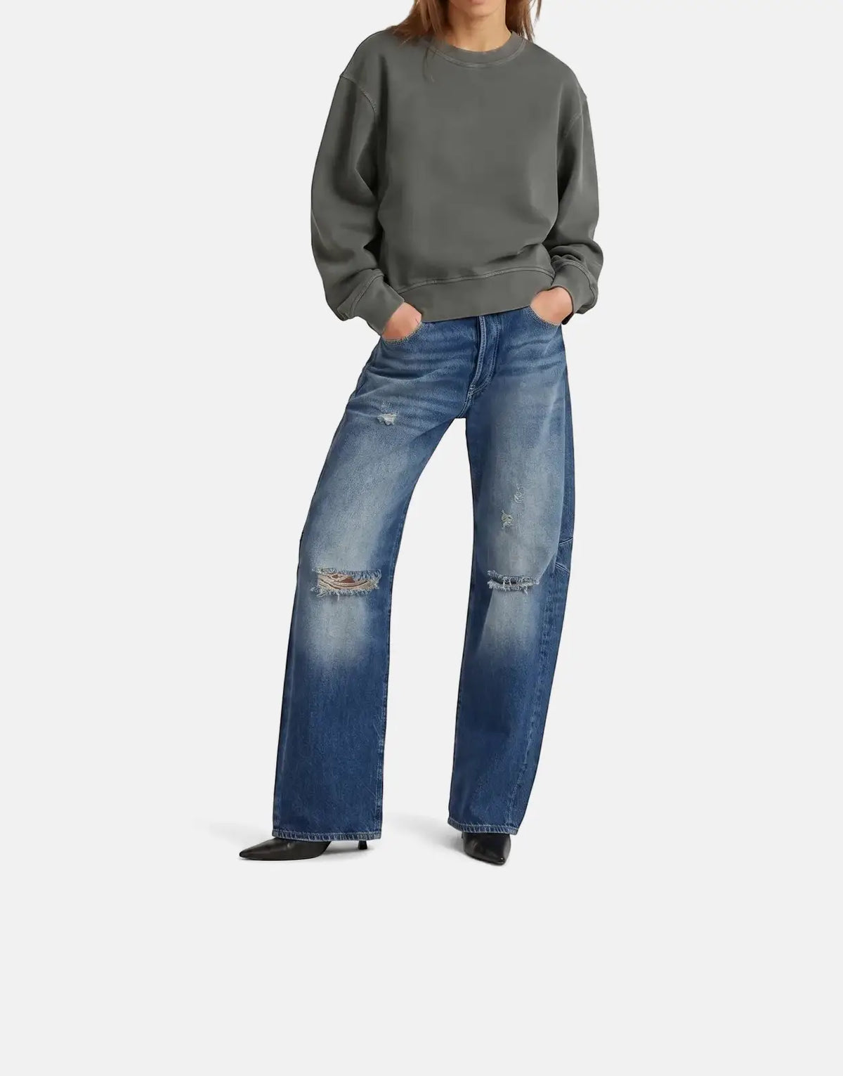 Female model wearing a dark grey G-Star RAW Modern Basic Relaxed sweatshirt and distressed wide-leg blue jeans.