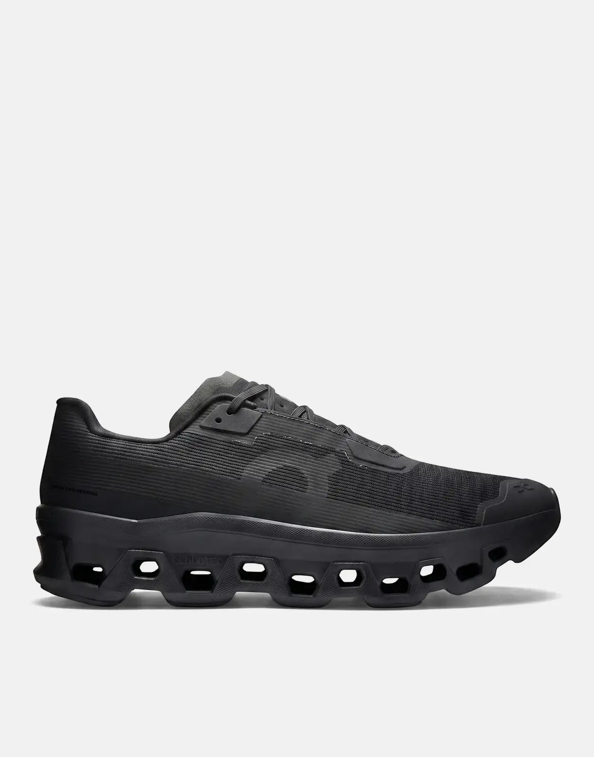 On Men's Cloudmonster Void Black Sneaker, a sleek black running shoe with a unique textured upper and Cloudtec sole, viewed