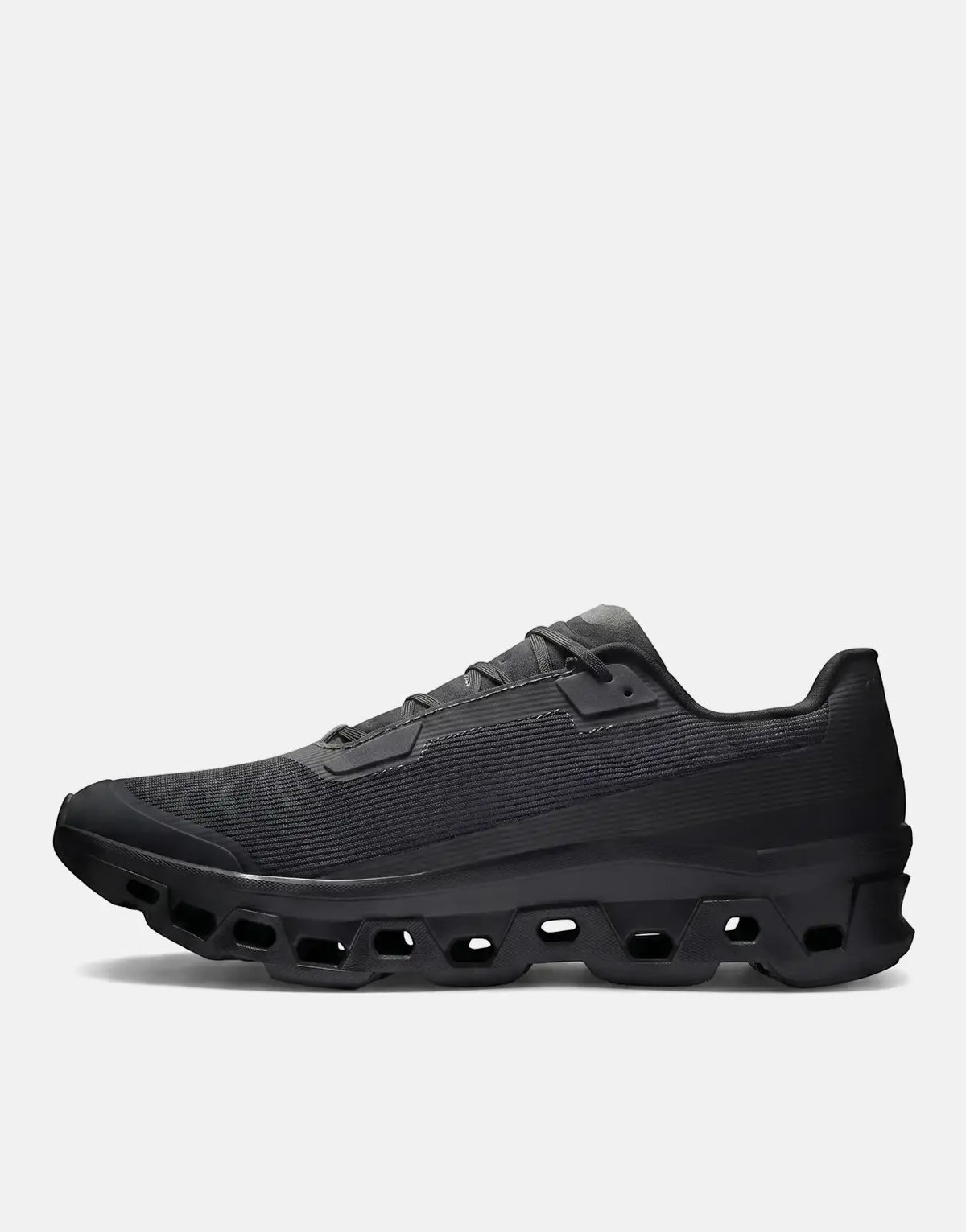 On Men's Cloudmonster Void Black Sneaker, a sleek running shoe with a distinctive CloudTec sole, shown from a side profile