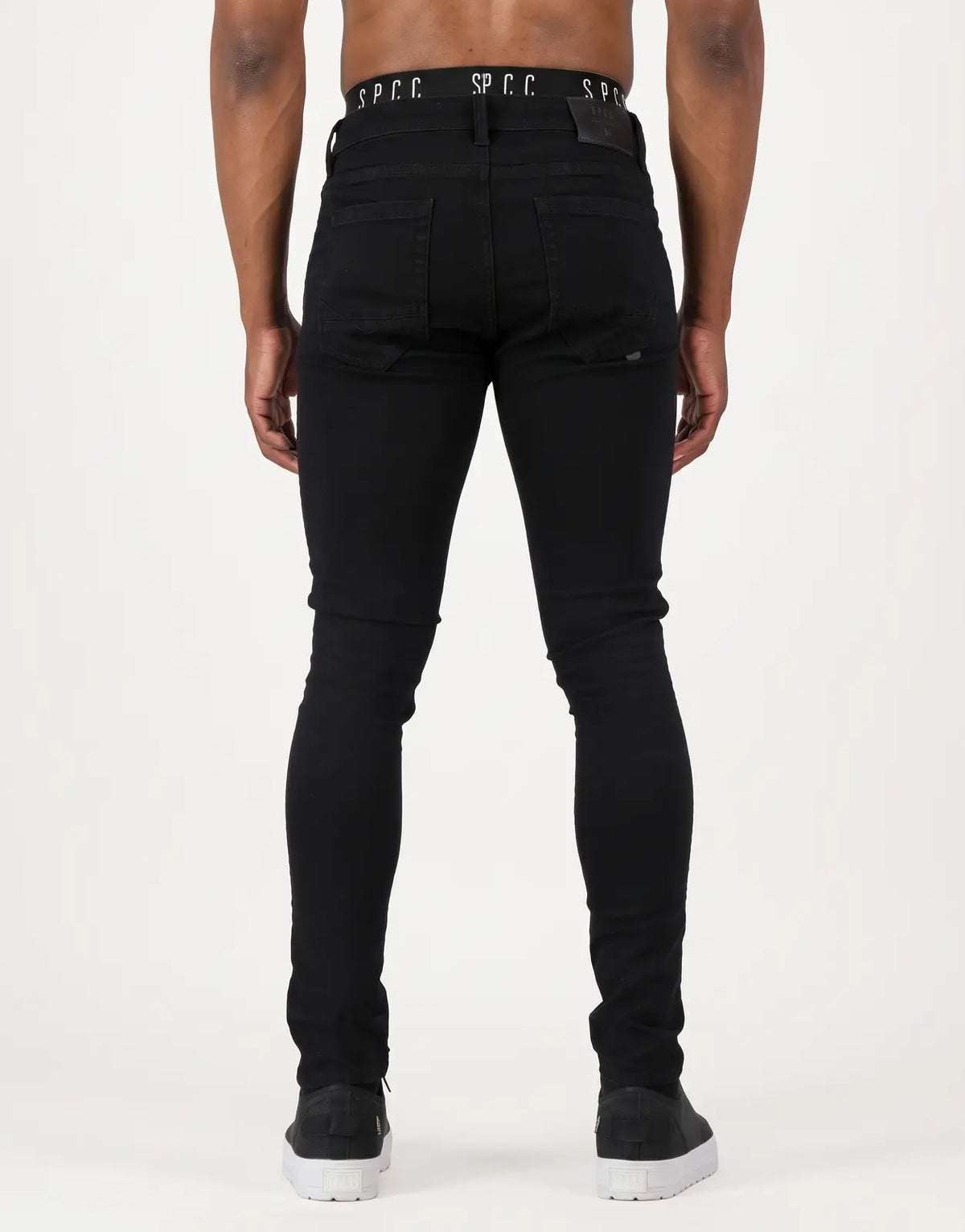 SPCC Eclipse Jeans in black skinny fit, featuring distressed details and branding on the waistband, shown from the back.