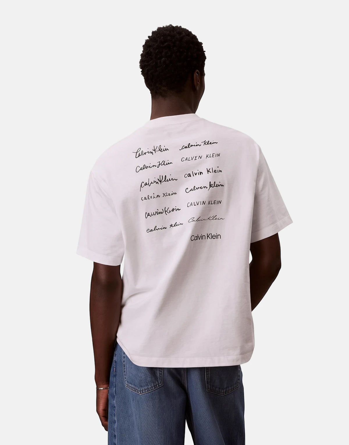 Model wearing a white Calvin Klein 16s April Graphic Seasonal Fashion T-Shirt, viewed from the back, showcasing multiple