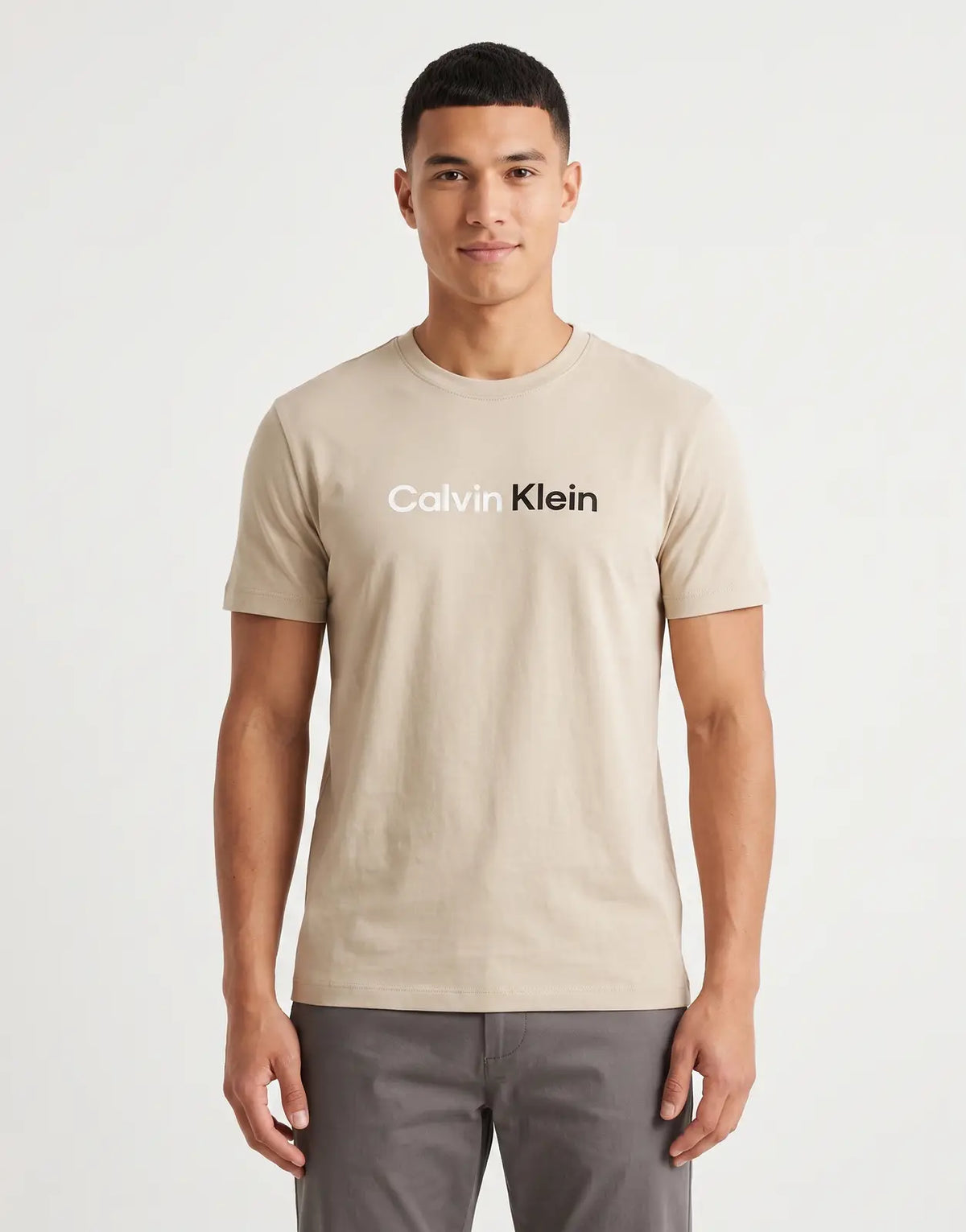A beige Calvin Klein 30s Wholesale Jeans graphic T-shirt, made from soft cotton, displayed flat, front view.