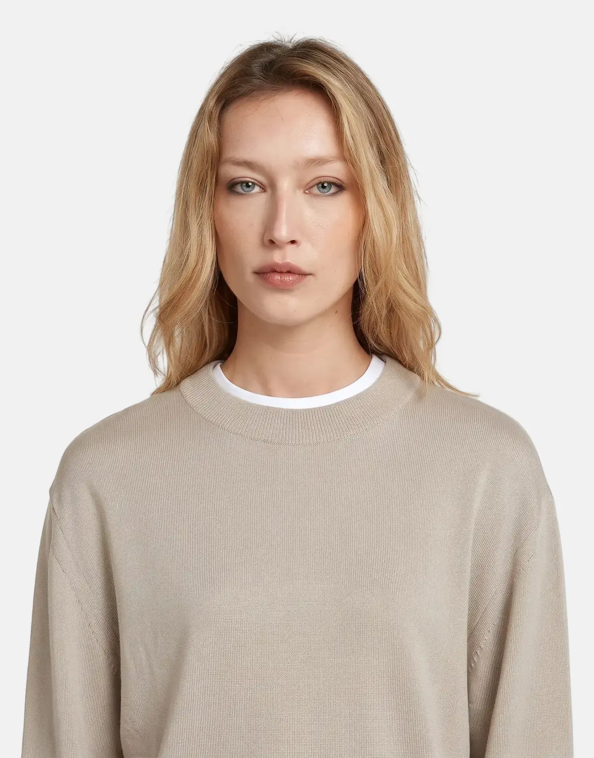 Close-up of a blonde woman wearing a G-Star RAW Boxy Knit Brick sweater in a light beige color, looking directly forward.