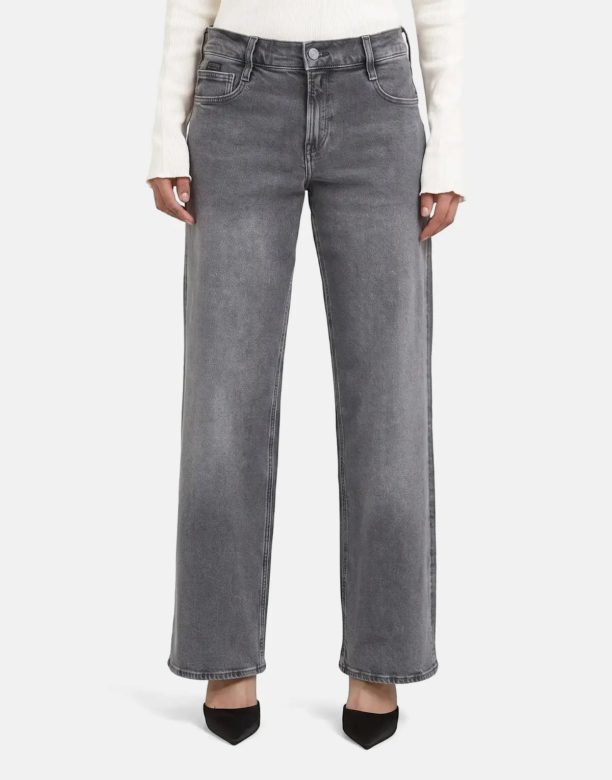 Model wearing G-Star RAW Judee Loose Faded Blade faded gray wide-leg denim jeans with a white sweater and black heels.