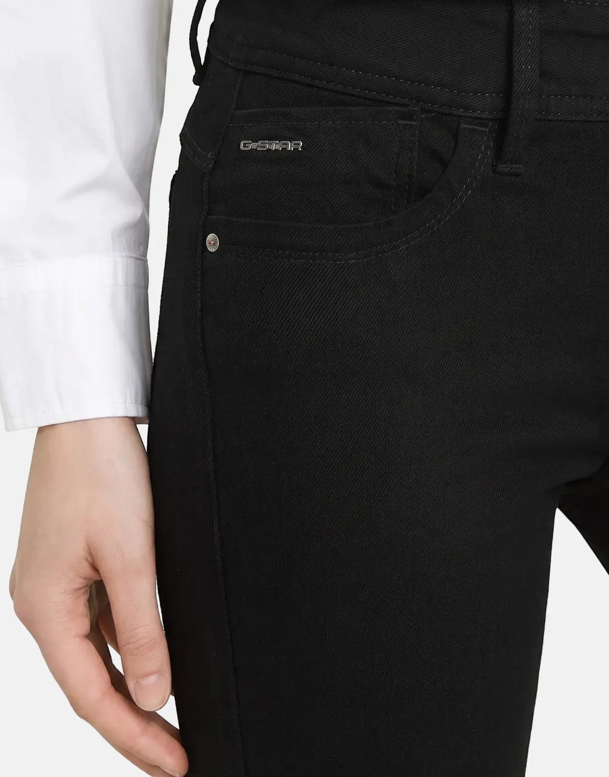 Close-up of G-Star RAW Lynn Mid Skinny Pitch Black Jeans worn by a model, featuring front pocket with logo and hand.