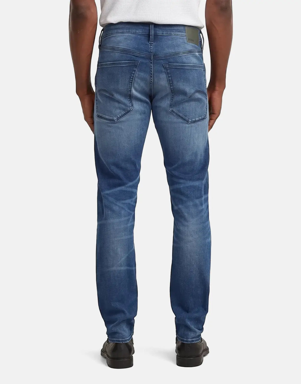 Men's G-Star RAW Streem Slim Tapered jeans in a worn medium blue wash, shown from the back.