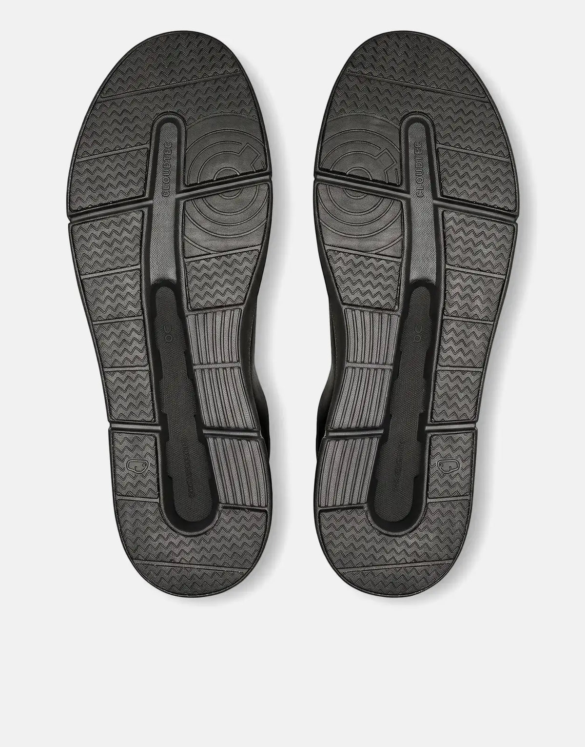 Pair of On Men's Roger Advantage black sneakers, viewed from below showing the textured soles.