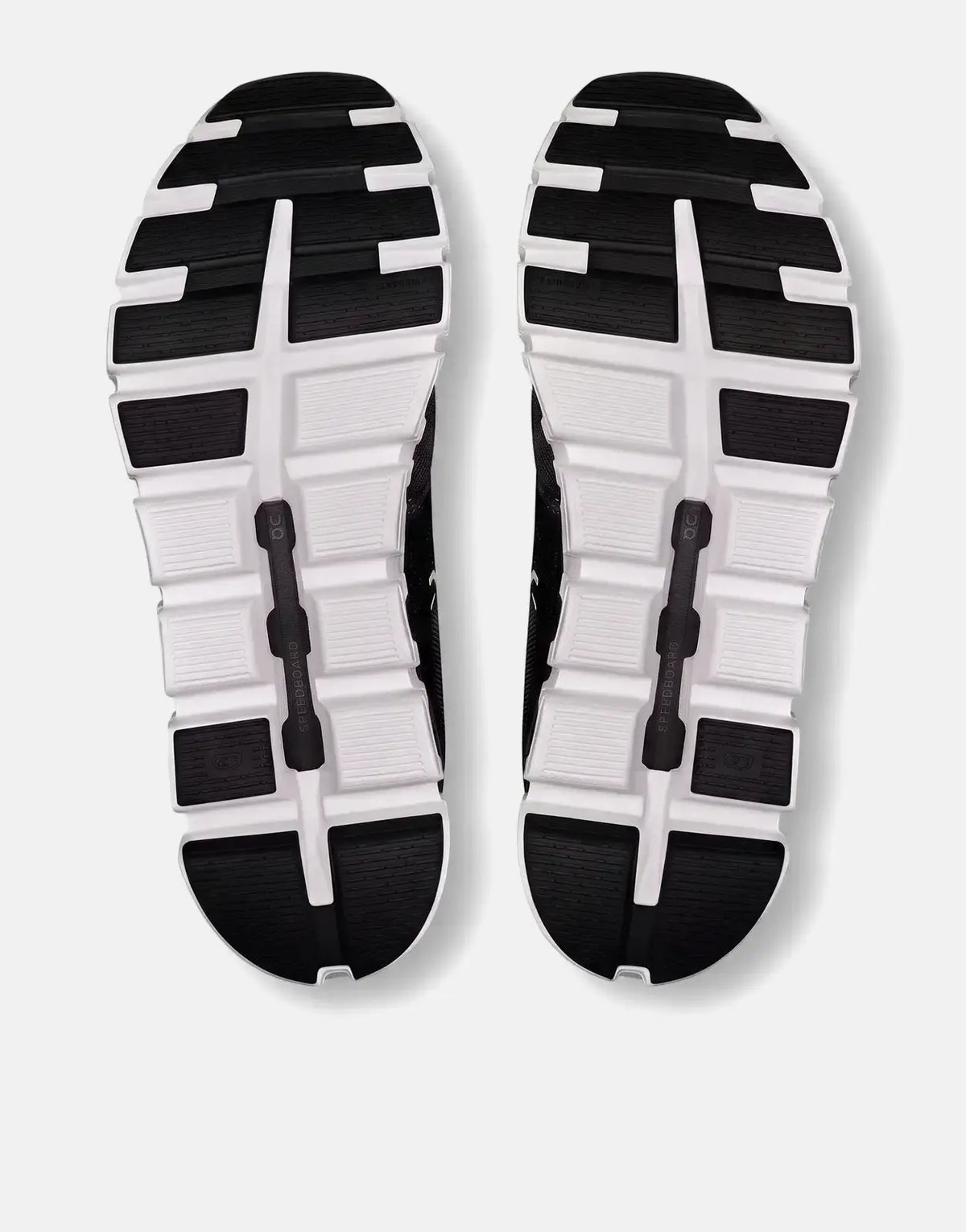 Bottom view of On Women's Cloud 6 sneakers in black and white, showcasing the patterned rubber soles.