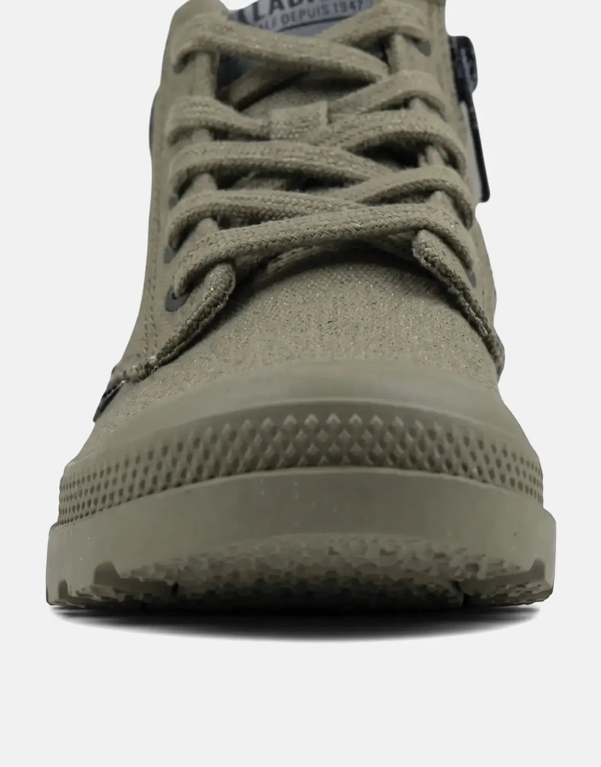 Front view of a khaki green Palladium OLN Pampa Kids canvas boot with laces and a textured rubber toe cap.