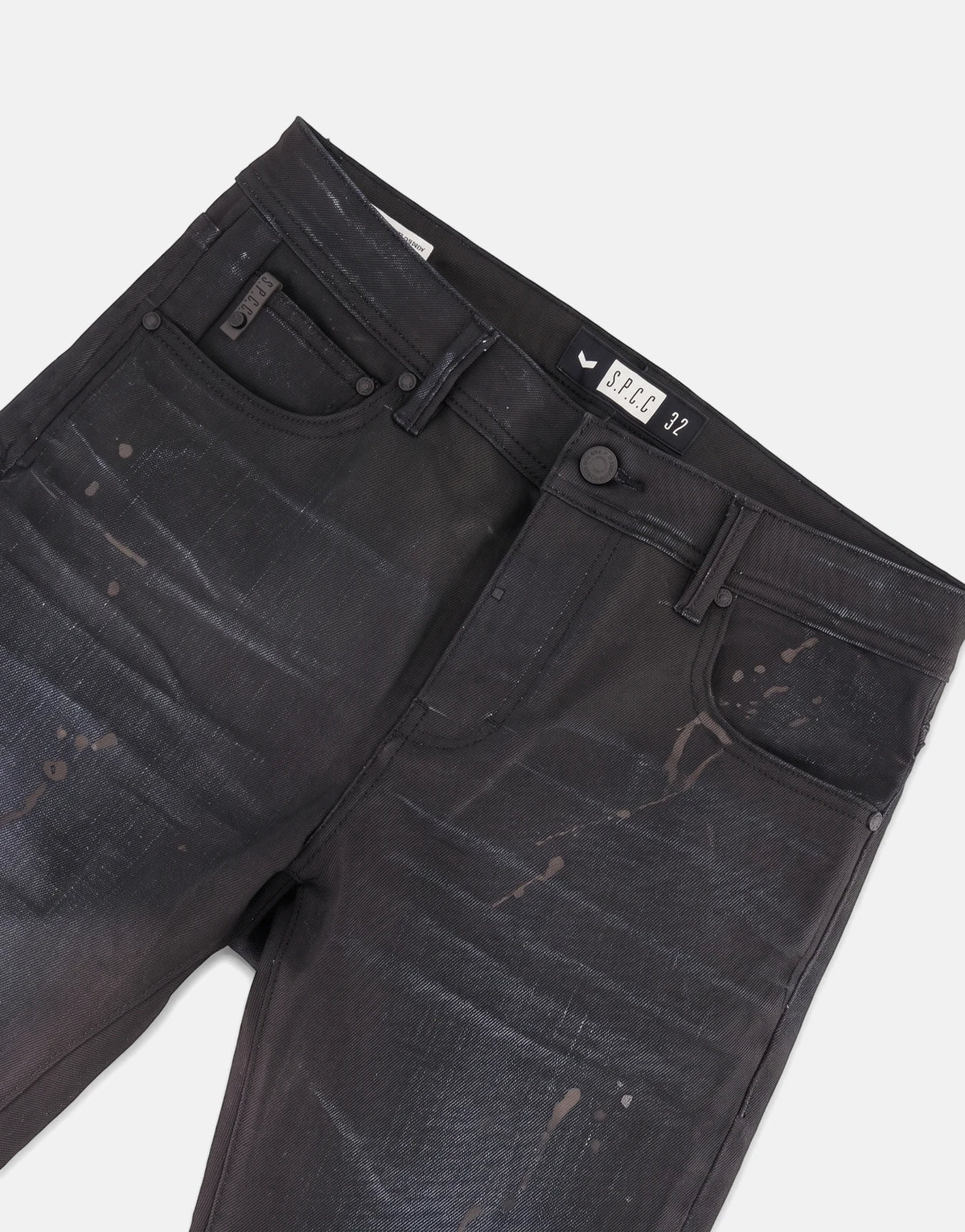 Close-up of SPCC Eclipse Jeans for men, featuring dark black denim with distressed paint splatter details and visible front